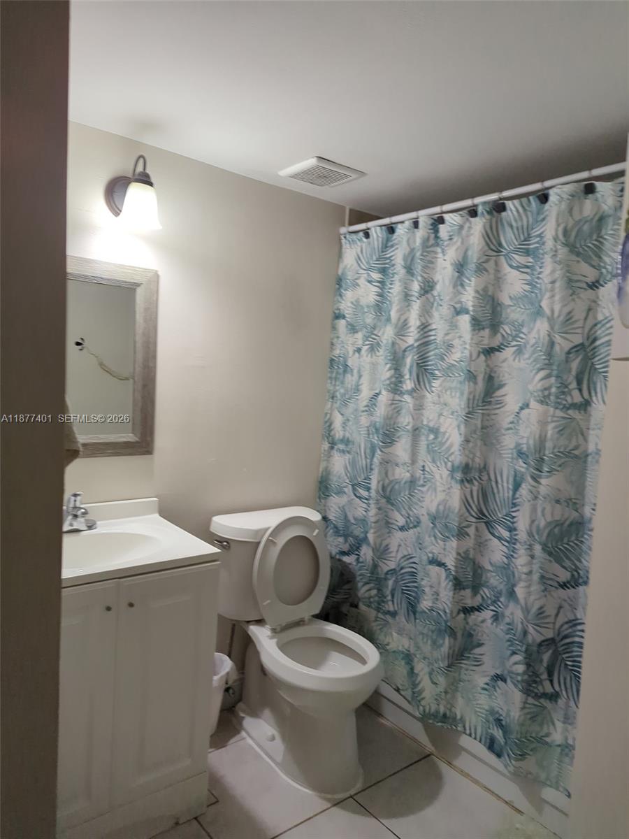 8205 Southwest 152nd Avenue, Unit F414 Miami, FL 33193 - Photo 12 of 13 a white toilet sitting next to a bathroom sink