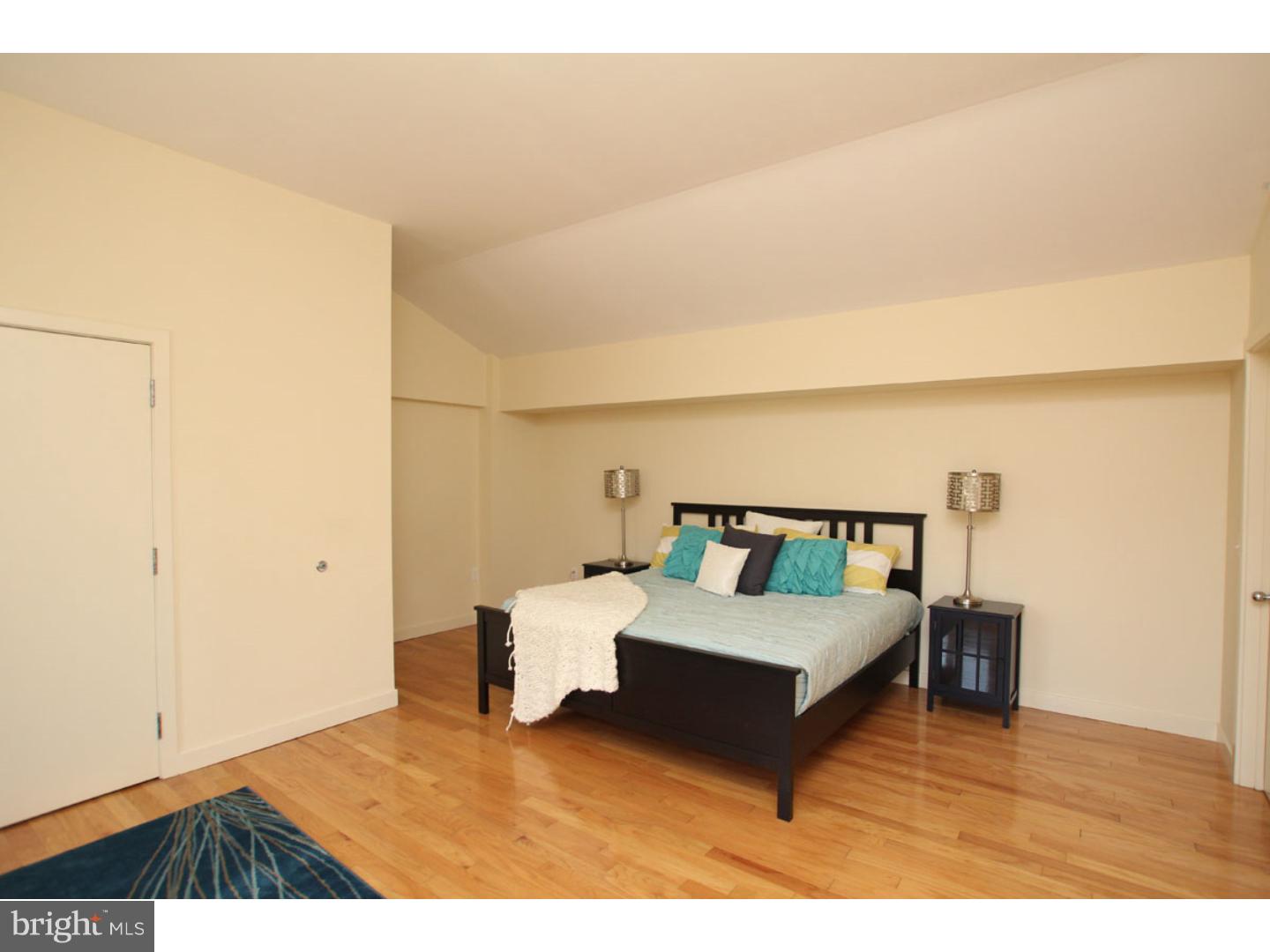 1900 Hamilton Street, Unit D19 Philadelphia, PA 19130 - Photo 11 of 25 a bedroom with a bed and a night stand