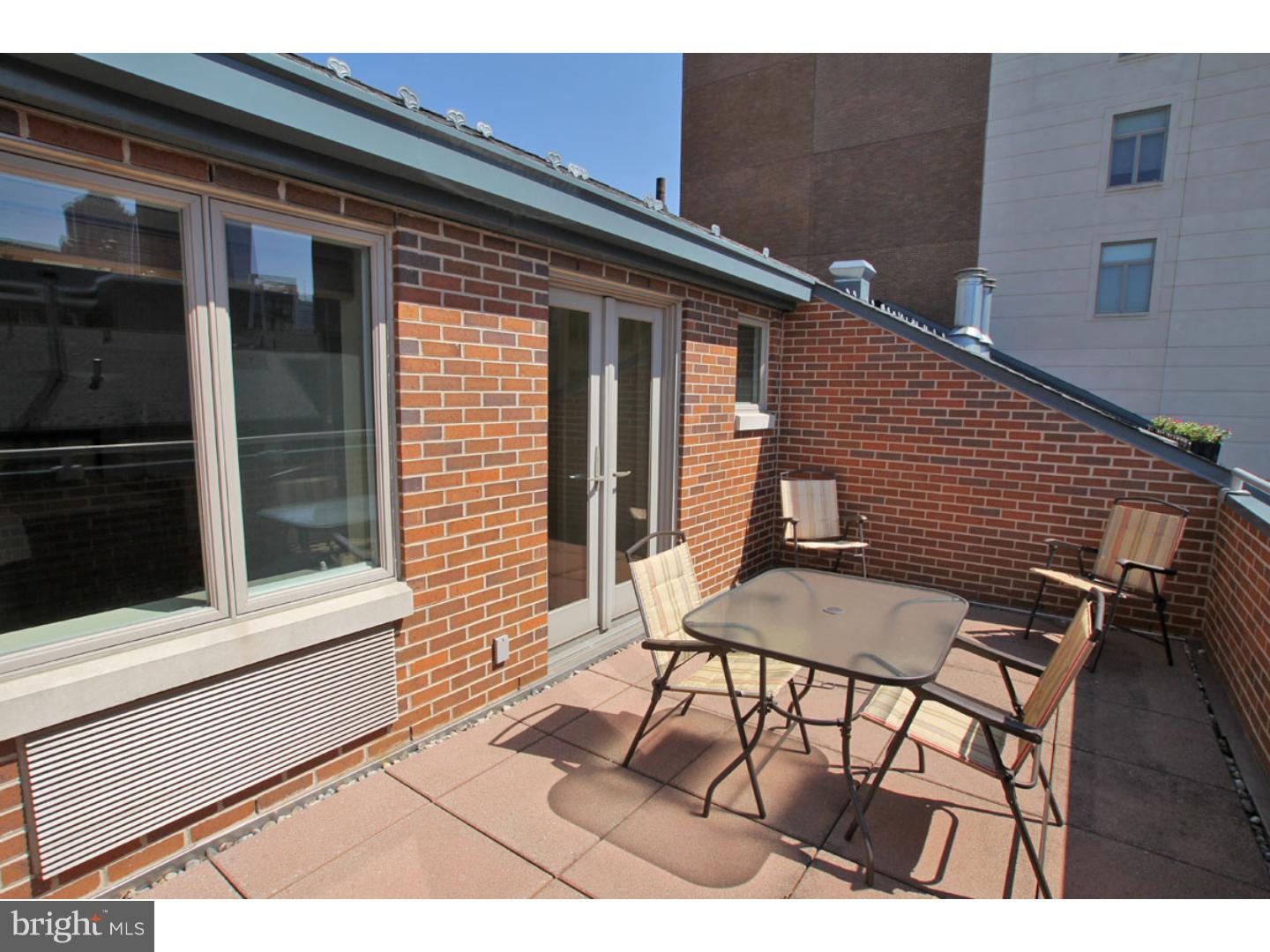 1900 Hamilton Street, Unit D19 Philadelphia, PA 19130 - Photo 14 of 25 a view of a patio with table and chairs with barbeque grill and wooden floor