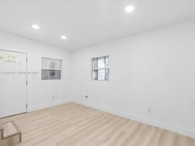 a view of an empty room with wooden floor and closet