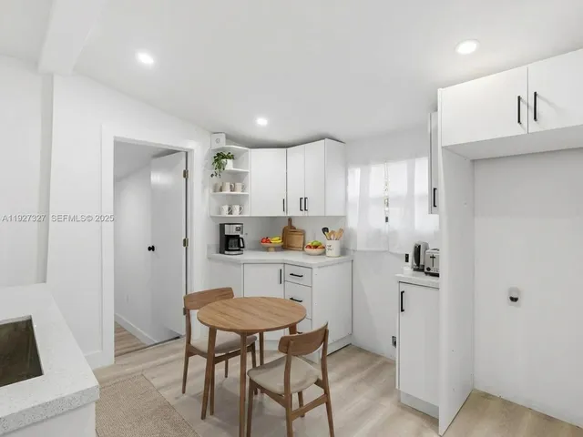 a kitchen with a refrigerator and white cabinets