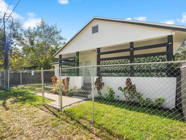 a view of a house with backyard and sitting area
