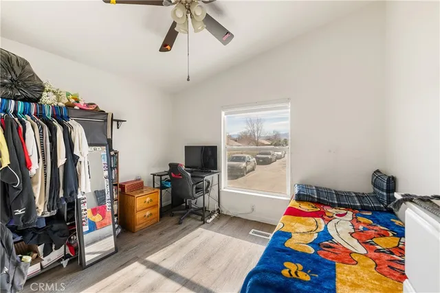 a bedroom with a bed a flat screen tv and a window