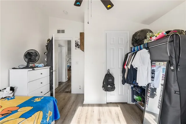 a bedroom with a bed and a mirror on the dresser