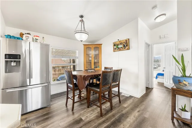 a view of a dining room with furniture a chandelier and wooden floor