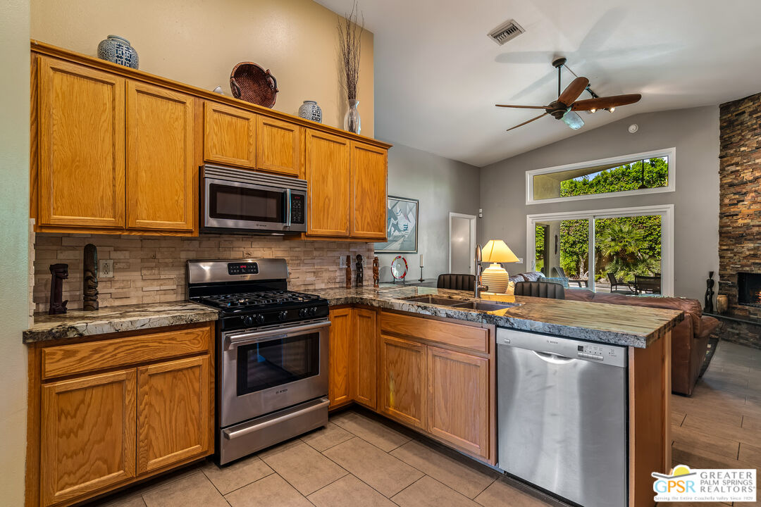 67860 Ontina Road Cathedral City, CA 92234 - Photo 11 of 48 a kitchen with stainless steel appliances granite countertop a sink and cabinets