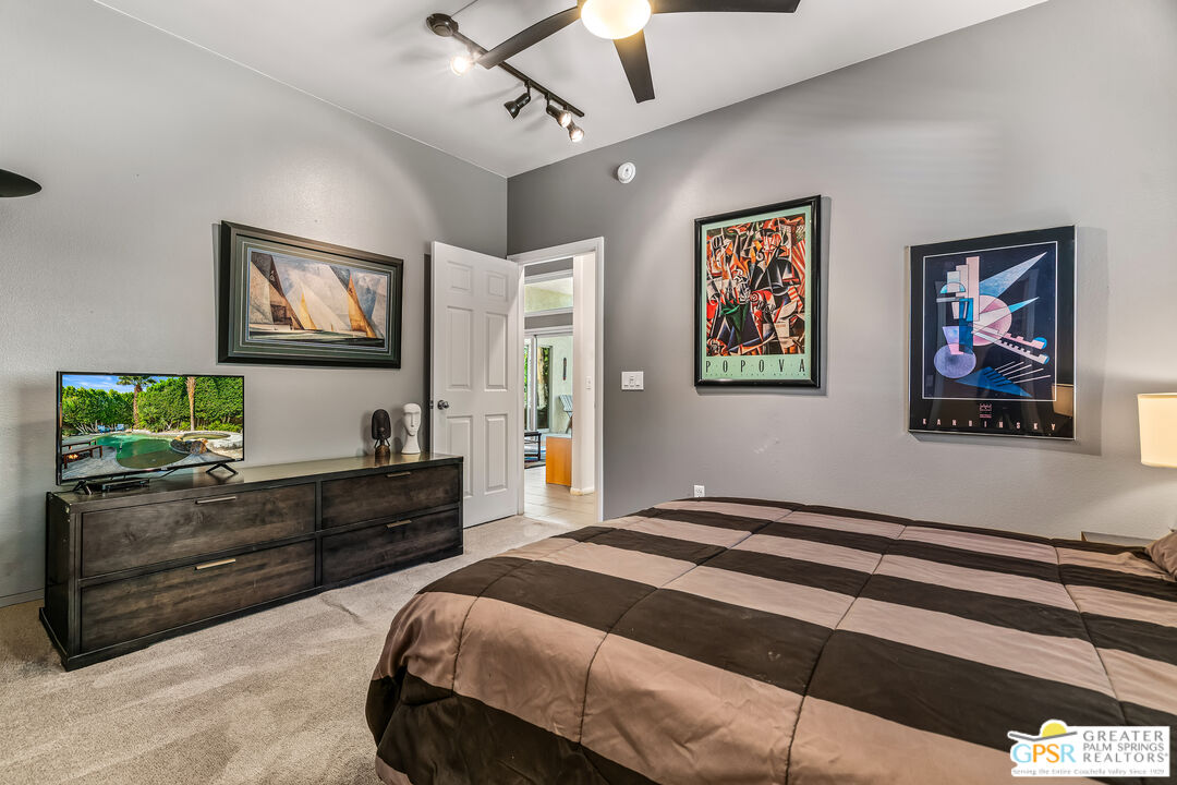 67860 Ontina Road Cathedral City, CA 92234 - Photo 29 of 48 a bedroom with a bed and a chandelier