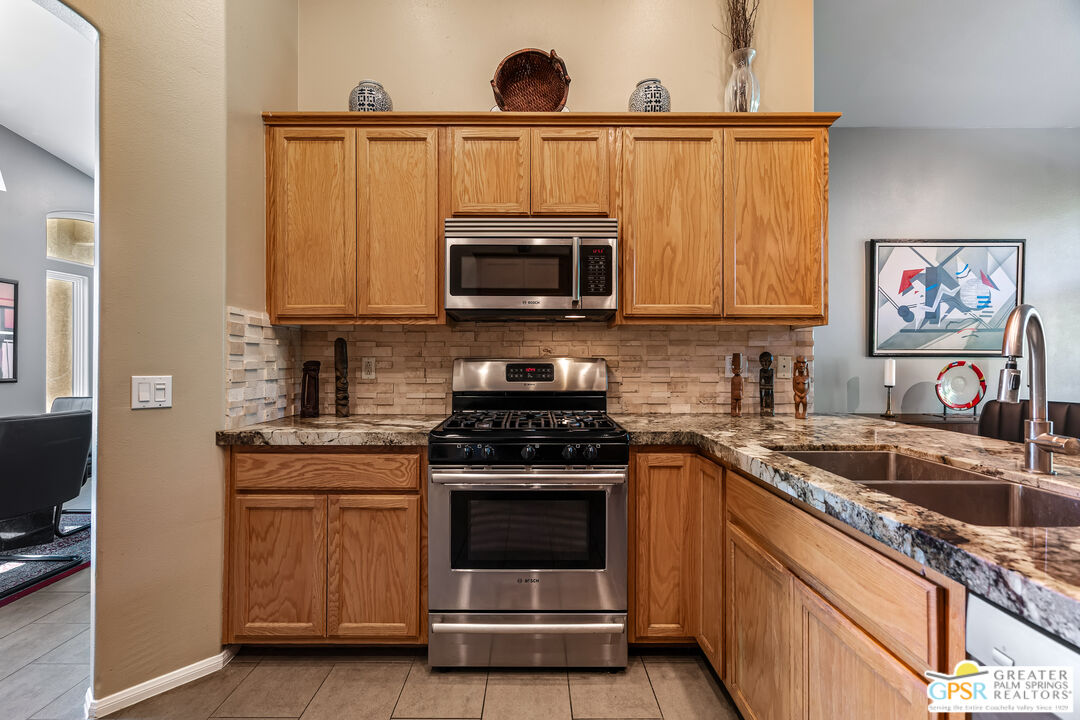 67860 Ontina Road Cathedral City, CA 92234 - Photo 10 of 48 a kitchen with granite countertop a stove a sink and a microwave