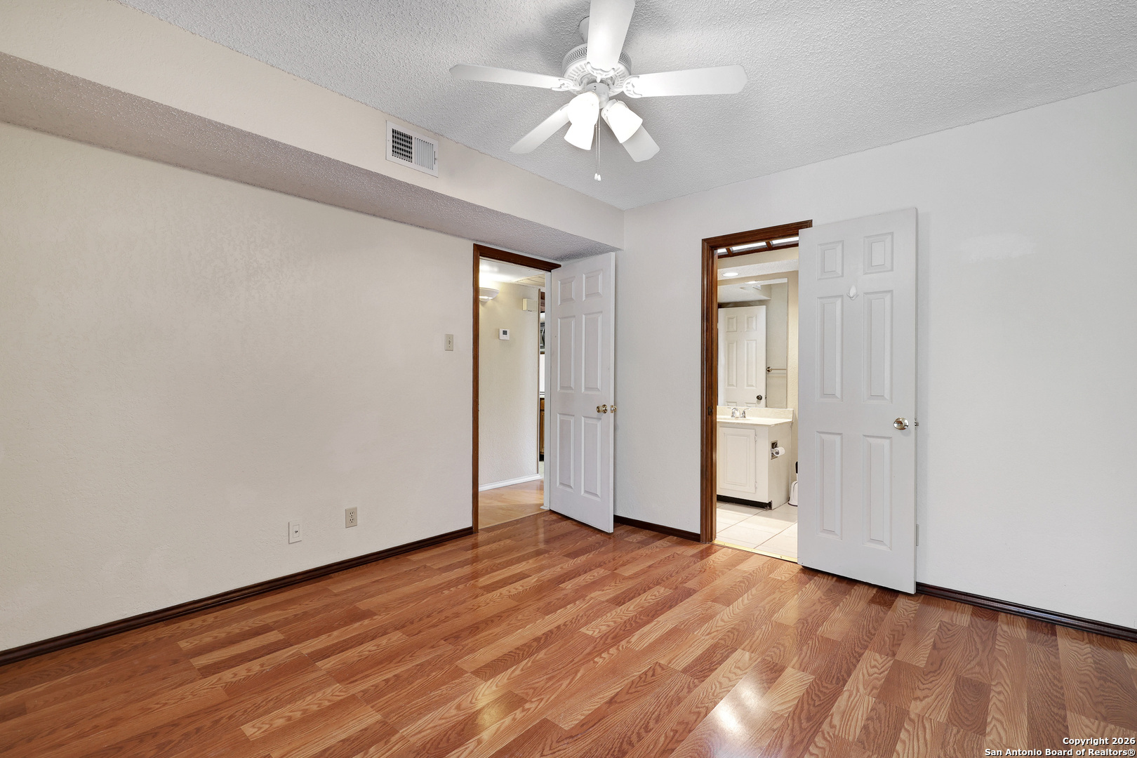 8633 Datapoint Drive, Unit 224 San Antonio, TX 78229 - Photo 16 of 27 an empty room with wooden floor and ceiling fan