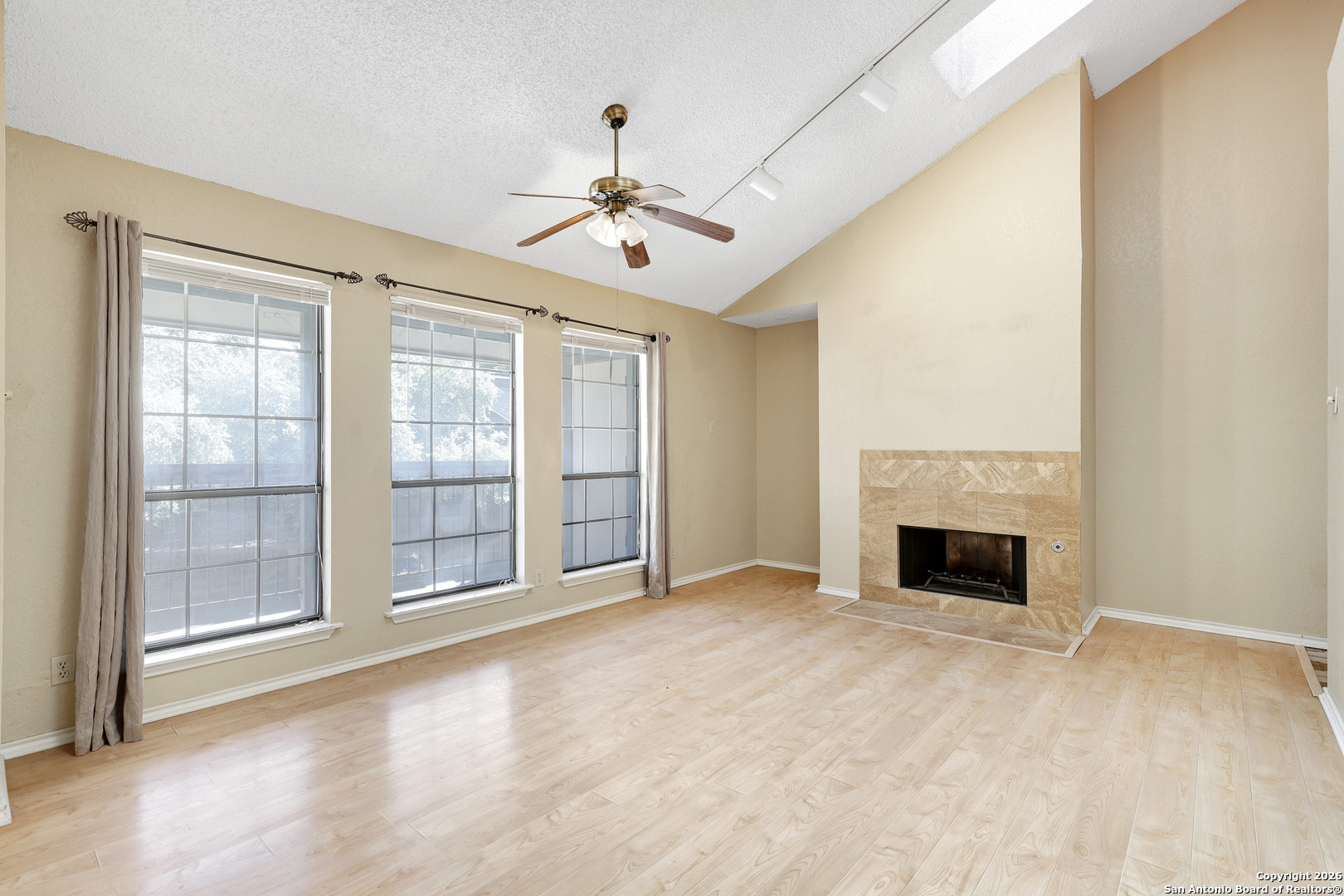 8633 Datapoint Drive, Unit 224 San Antonio, TX 78229 - Photo 4 of 27 a view of an empty room with chandelier fan and fire place
