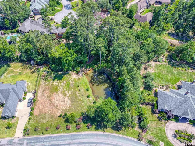 an aerial view of residential house with outdoor space and trees all around