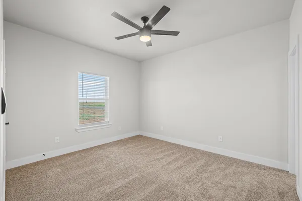 an empty room with a window and a ceiling fan