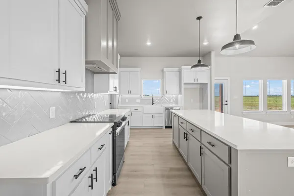 a large kitchen with stainless steel appliances kitchen island a large counter top and a stove top oven