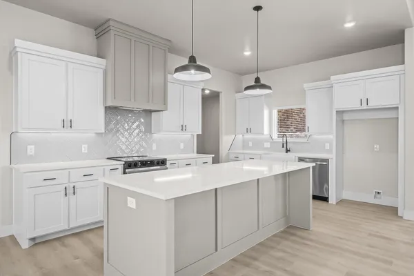 a kitchen with stainless steel appliances a stove sink and cabinets