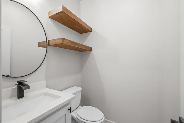 a bathroom with a sink and mirror with toilet