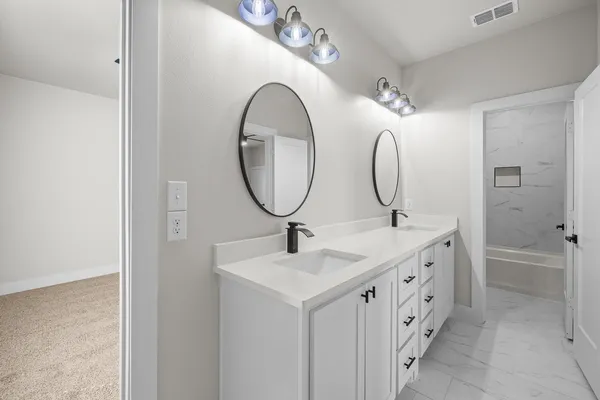 a bathroom with a double vanity sink double mirror and a mirror