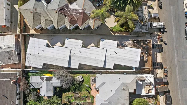 an aerial view of a house with a yard and large tree