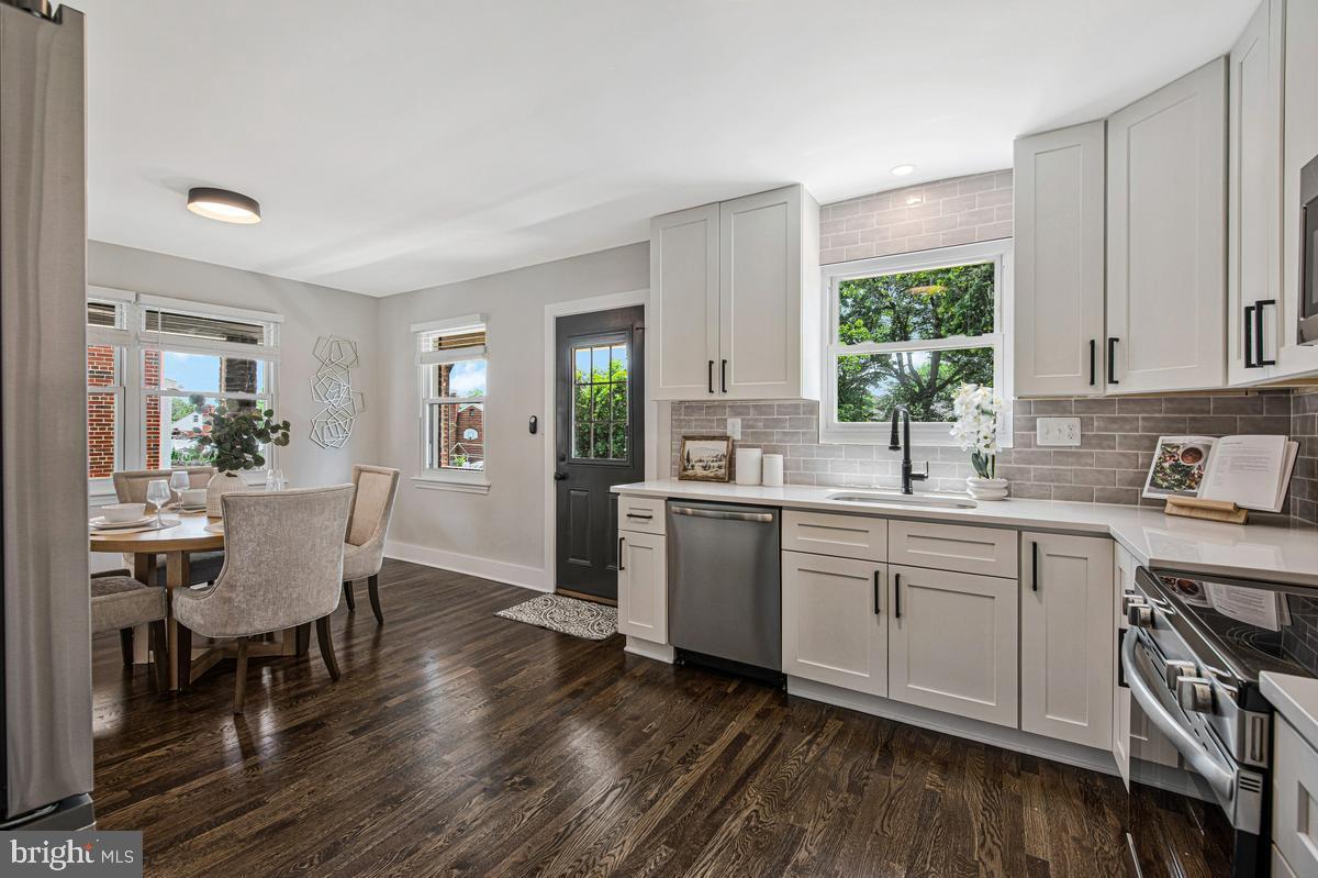 2105 Queens Chapel Road Mount Rainier, MD 20712 - Photo 2 of 33 a kitchen with sink cabinets and dining table