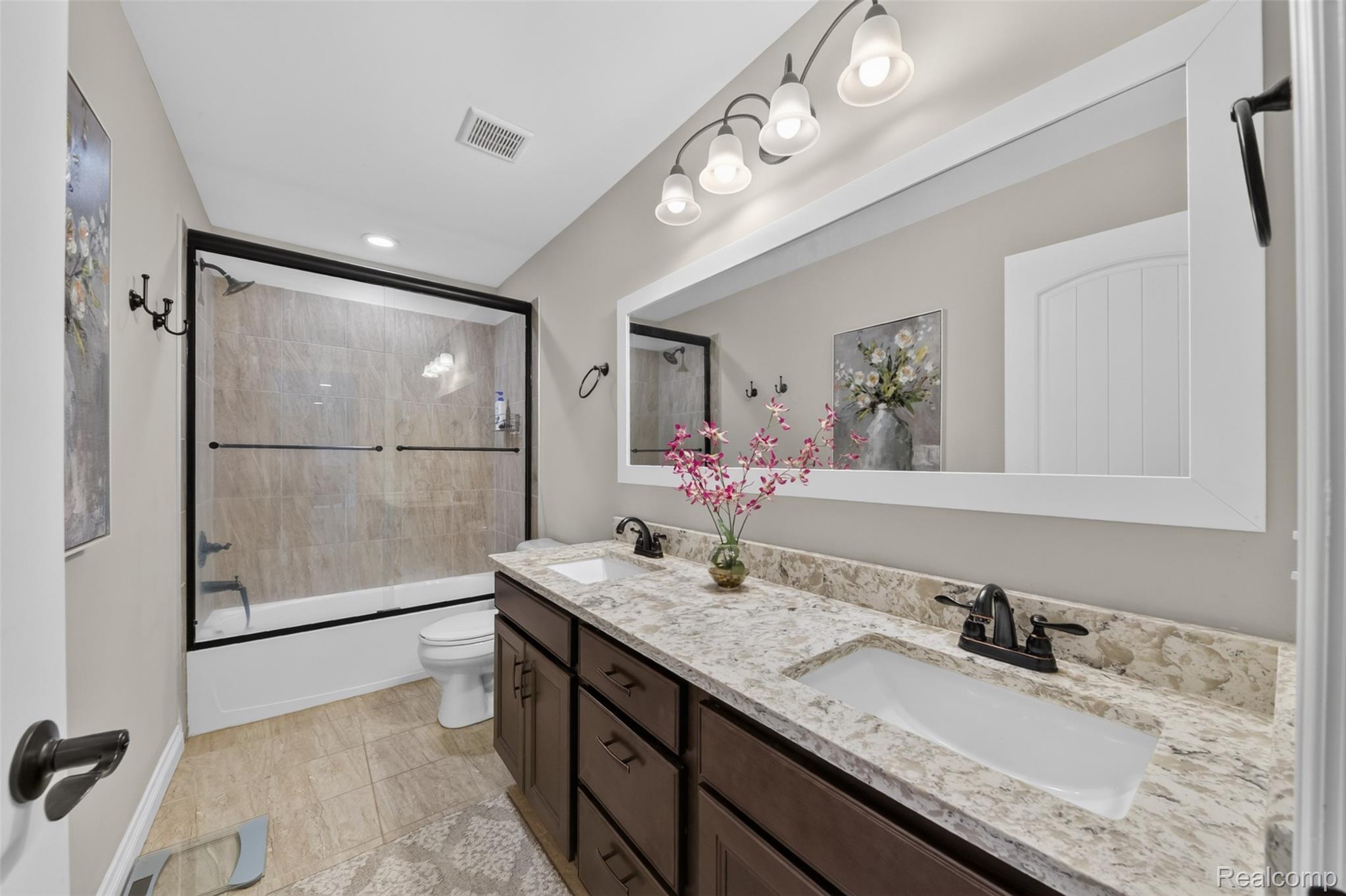 2531 Walnut View Drive Howell, MI 48855 - Photo 22 of 34 Double vanity with integrated sinks, granite countertop, and dark wood cabinetry