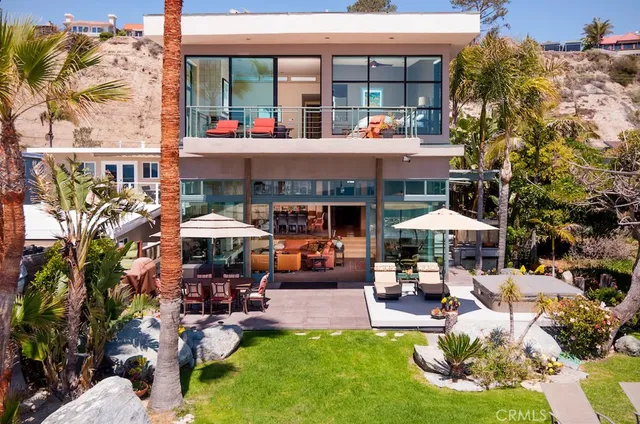 a view of the patio with dining table and chairs under an umbrella