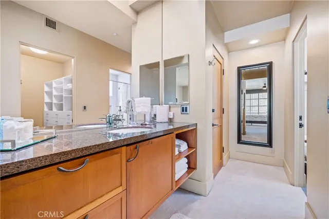a bathroom with a granite countertop sink toilet a large mirror a bathtub and shower
