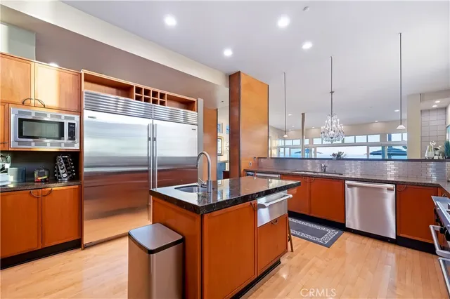 a kitchen with stainless steel appliances granite countertop a refrigerator a sink and a stove