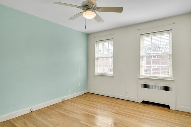 46 Browne Street, Unit 1 Brookline, MA 02446 - Photo 10 of 15 an empty room with wooden floor chandelier fan and windows