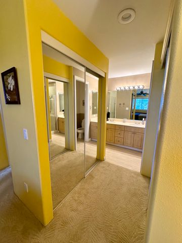 a view of a hallway with furniture and a bathroom