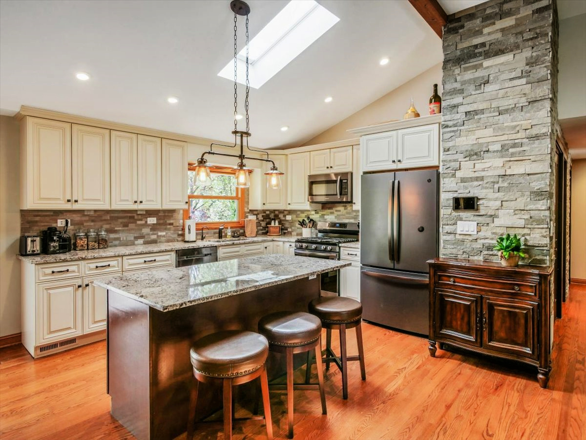 333 Rugby Place Schaumburg, IL 60169 - Photo 8 of 34 a kitchen with refrigerator cabinets dining table and chairs