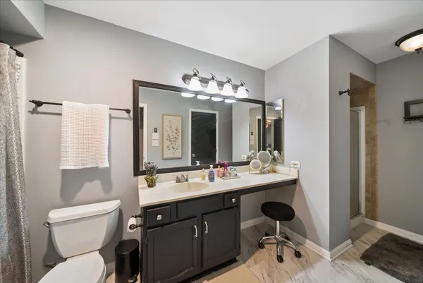 a bathroom with a sink vanity mirror and toilet