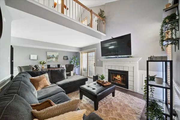 a living room with furniture a flat screen tv and a fireplace