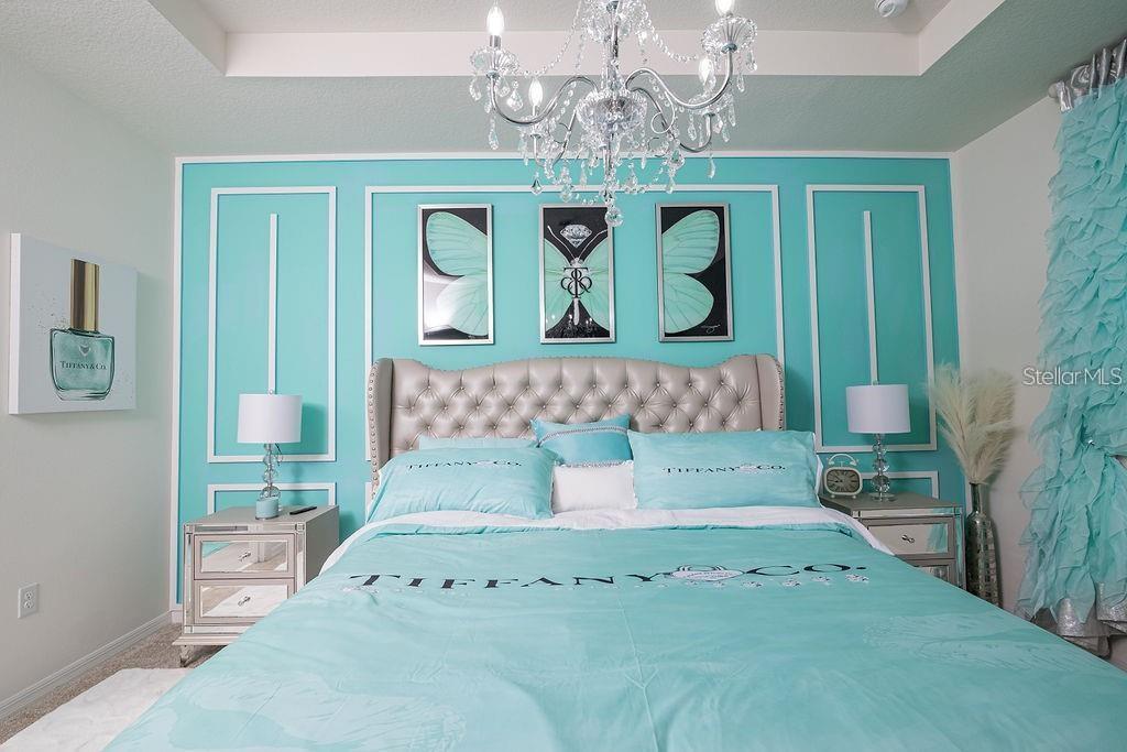 2937 Hooded Crane Cove Harmony, FL 34773 - Photo 31 of 58 a bedroom with a bed and a chandelier