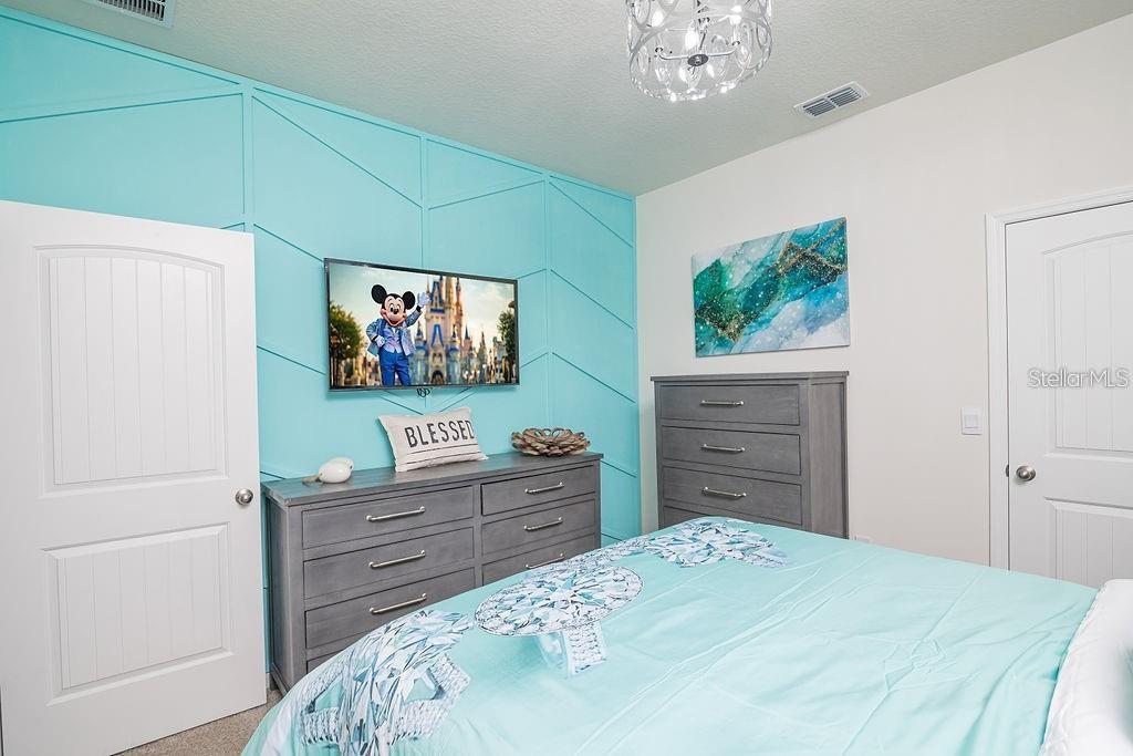 2937 Hooded Crane Cove Harmony, FL 34773 - Photo 42 of 58 a bedroom with a bed and a dresser