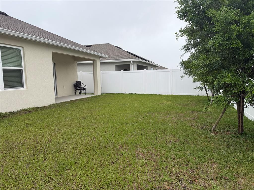 6772 Huntleigh Hammock Road St. Cloud, FL 34773 - Photo 12 of 14 a backyard of a house with table and chairs