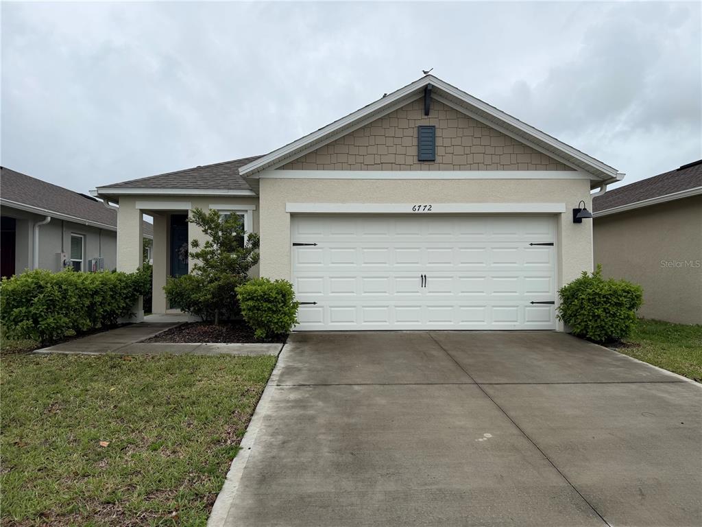 6772 Huntleigh Hammock Road St. Cloud, FL 34773 - Photo 2 of 14 a front view of house with yard and garage