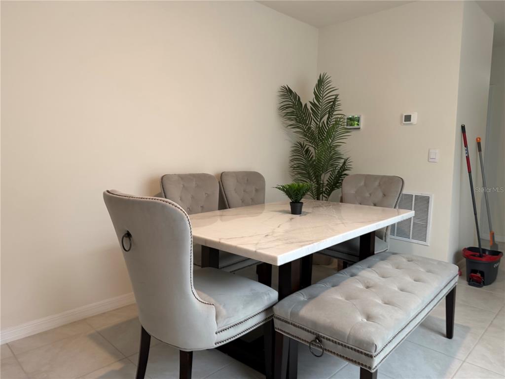 6772 Huntleigh Hammock Road St. Cloud, FL 34773 - Photo 4 of 14 a view of a dining room with furniture and wooden floor