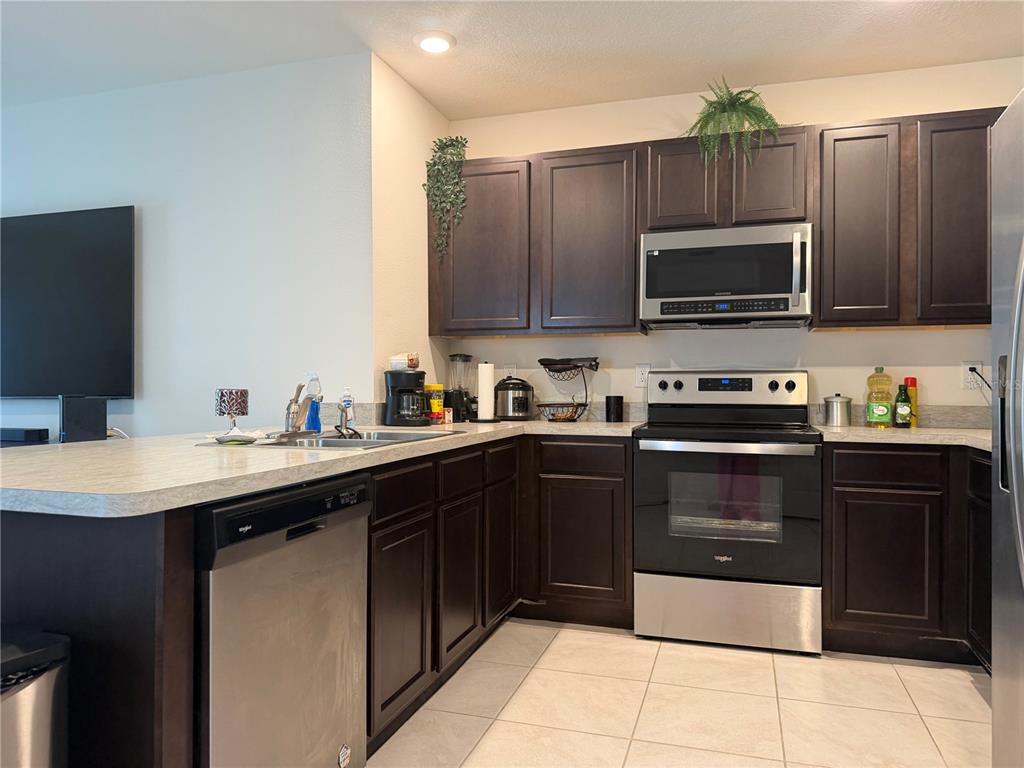 6772 Huntleigh Hammock Road St. Cloud, FL 34773 - Photo 6 of 14 a kitchen with a sink stove and microwave