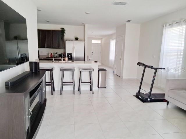 6772 Huntleigh Hammock Road St. Cloud, FL 34773 - Photo 8 of 14 a living room with furniture a flat screen tv and a window