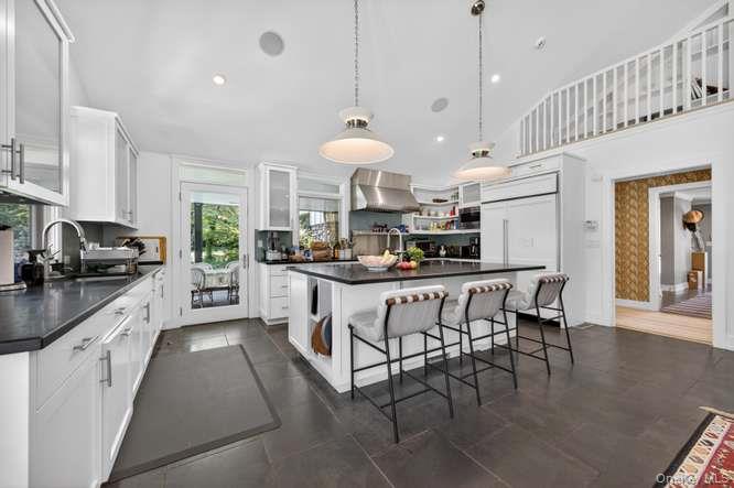 343 Chicken Valley Road Glen Head, NY 11545 - Photo 15 of 49 a kitchen with stainless steel appliances granite countertop a stove a sink a refrigerator and a dining table with wooden floor