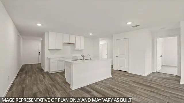 a kitchen with cabinets and wooden floor