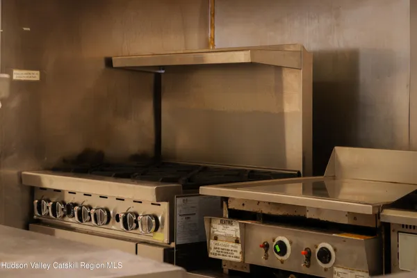 a kitchen with stainless steel appliances a stove and a flat screen tv