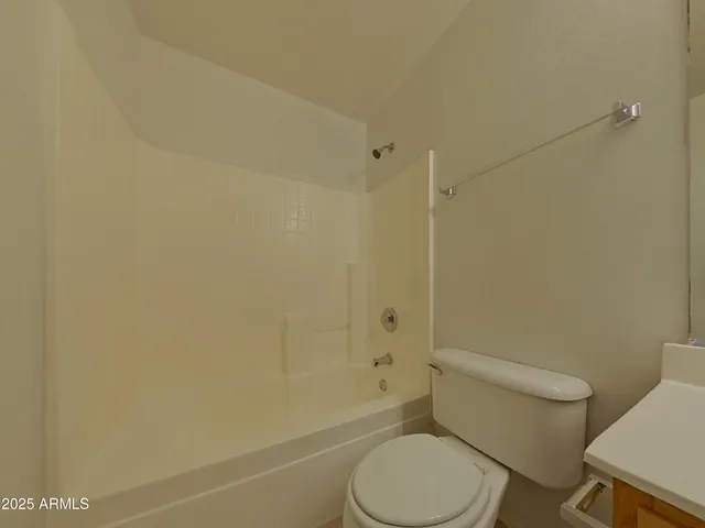a white toilet sitting next to a bathroom sink and a shower