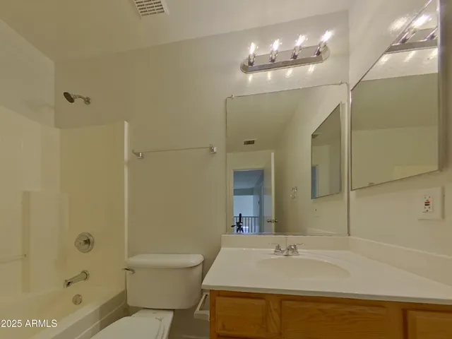 a bathroom with a sink a toilet a mirror and shower