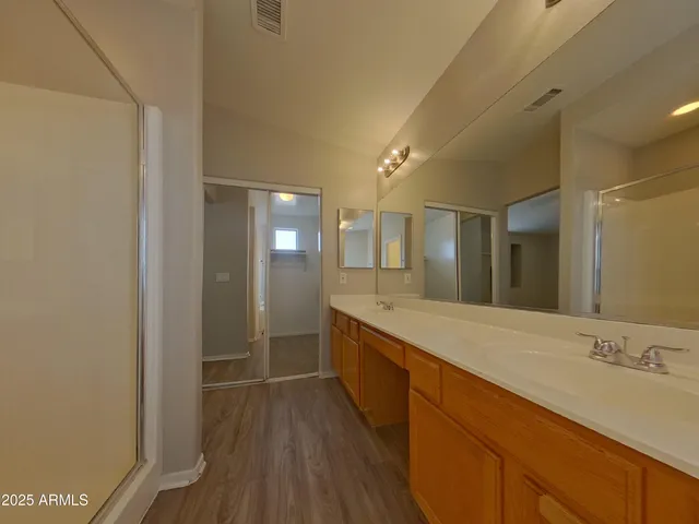 a spacious bathroom with a granite countertop sink mirror and shower