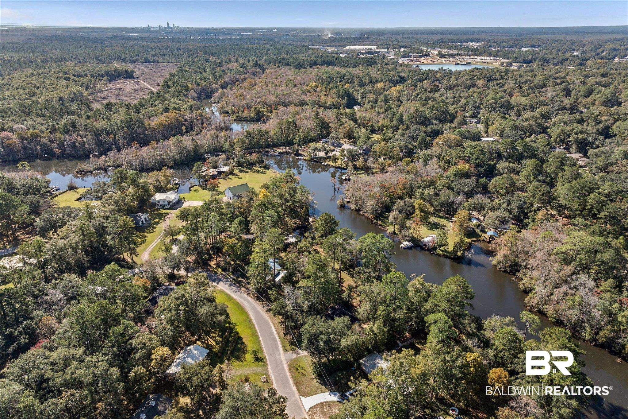 431 Simms Drive Saraland, AL 36571 - Photo 25 of 34 Aerial view of property's location with a heavily wooded area and a nearby body of water