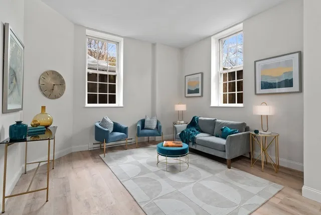 a living room with furniture and wall paintings