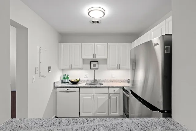 a kitchen with stainless steel appliances granite countertop a refrigerator sink and cabinets