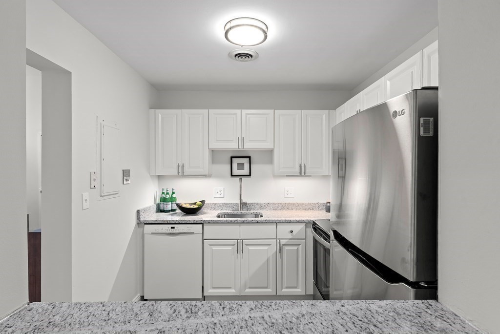 65 Glen Road, Unit H2 Brookline, MA 02445 - Photo 13 of 34 a kitchen with stainless steel appliances granite countertop a refrigerator sink and cabinets