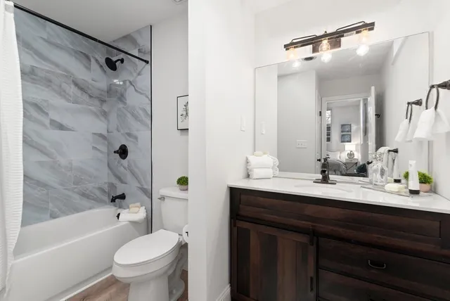 a bathroom with a sink a toilet and shower