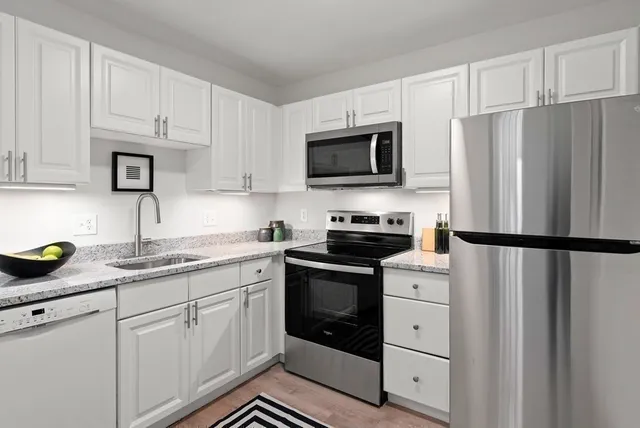 a kitchen with cabinets stainless steel appliances and a counter space